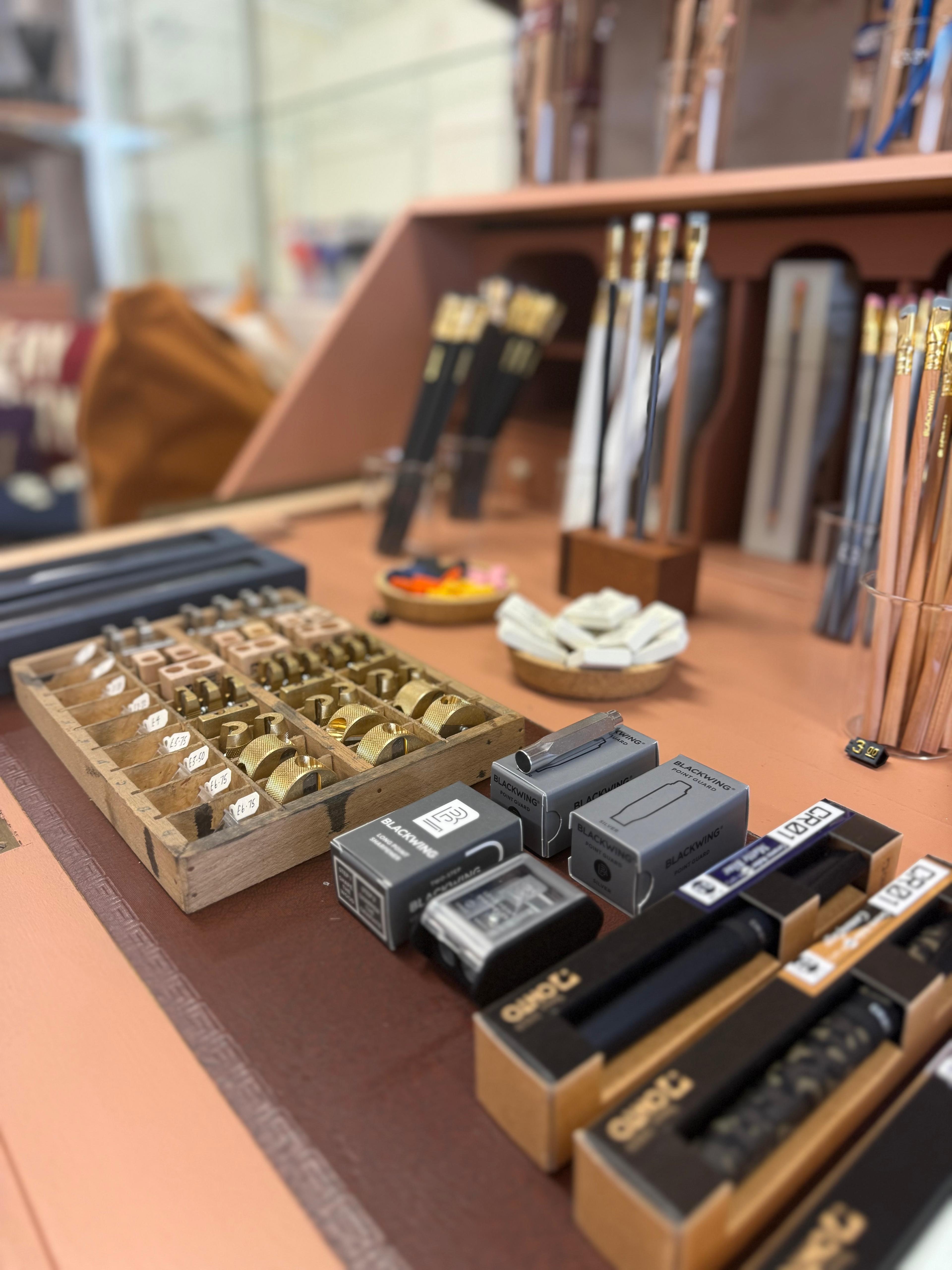Collection of writing instruments and accessories on a wooden surface